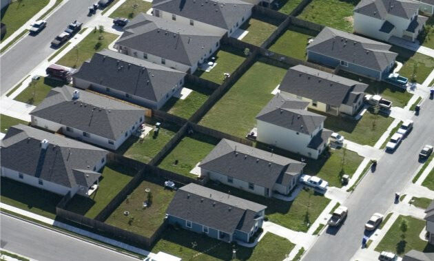 Casas em visão aérea construídas no meio do terreno.